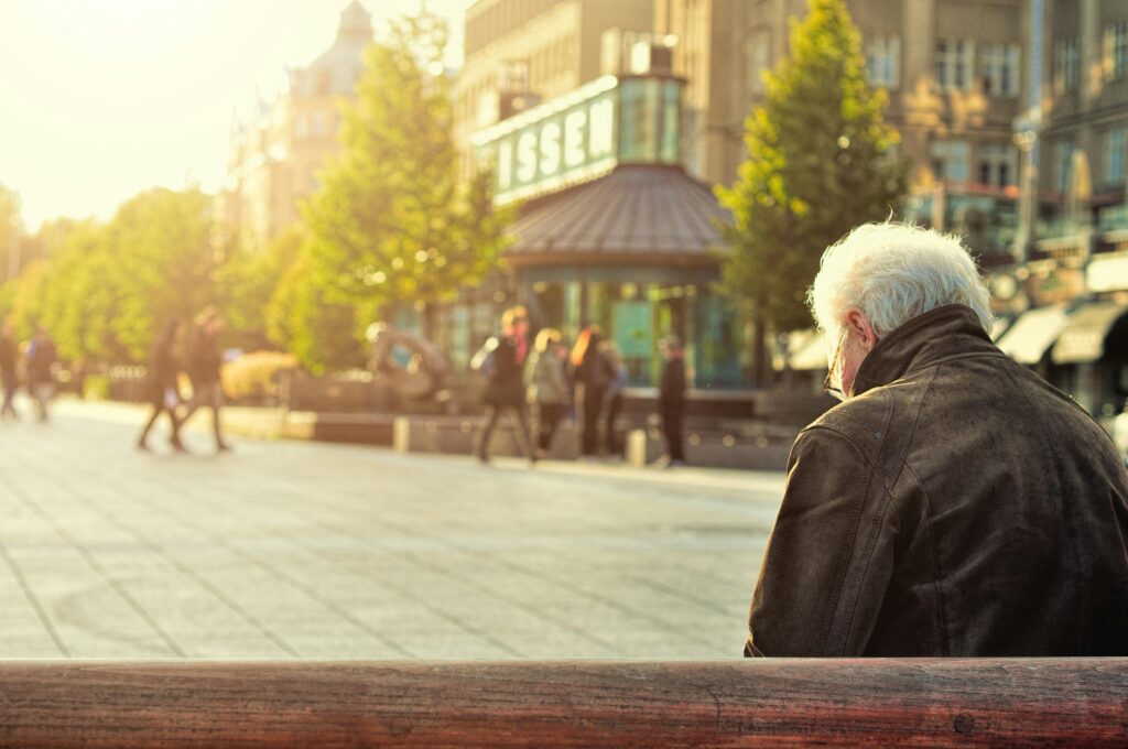 A senior man sitting on a bench in Jyväskylä, Finland. Captured during a sunny day in the city square.