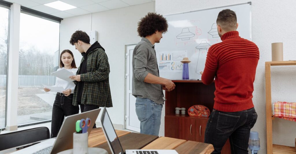 Young professionals brainstorming at a modern office with laptops and a whiteboard, showcasing teamwork and innovation.