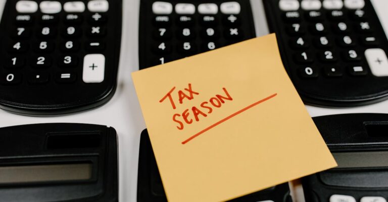 Close-up of calculators and a sticky note labeled 'Tax Season', symbolizing tax preparation.