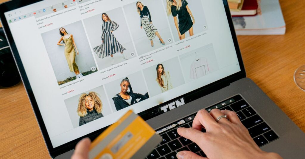 A woman makes an online purchase using a credit card on her laptop, browsing an online fashion store.